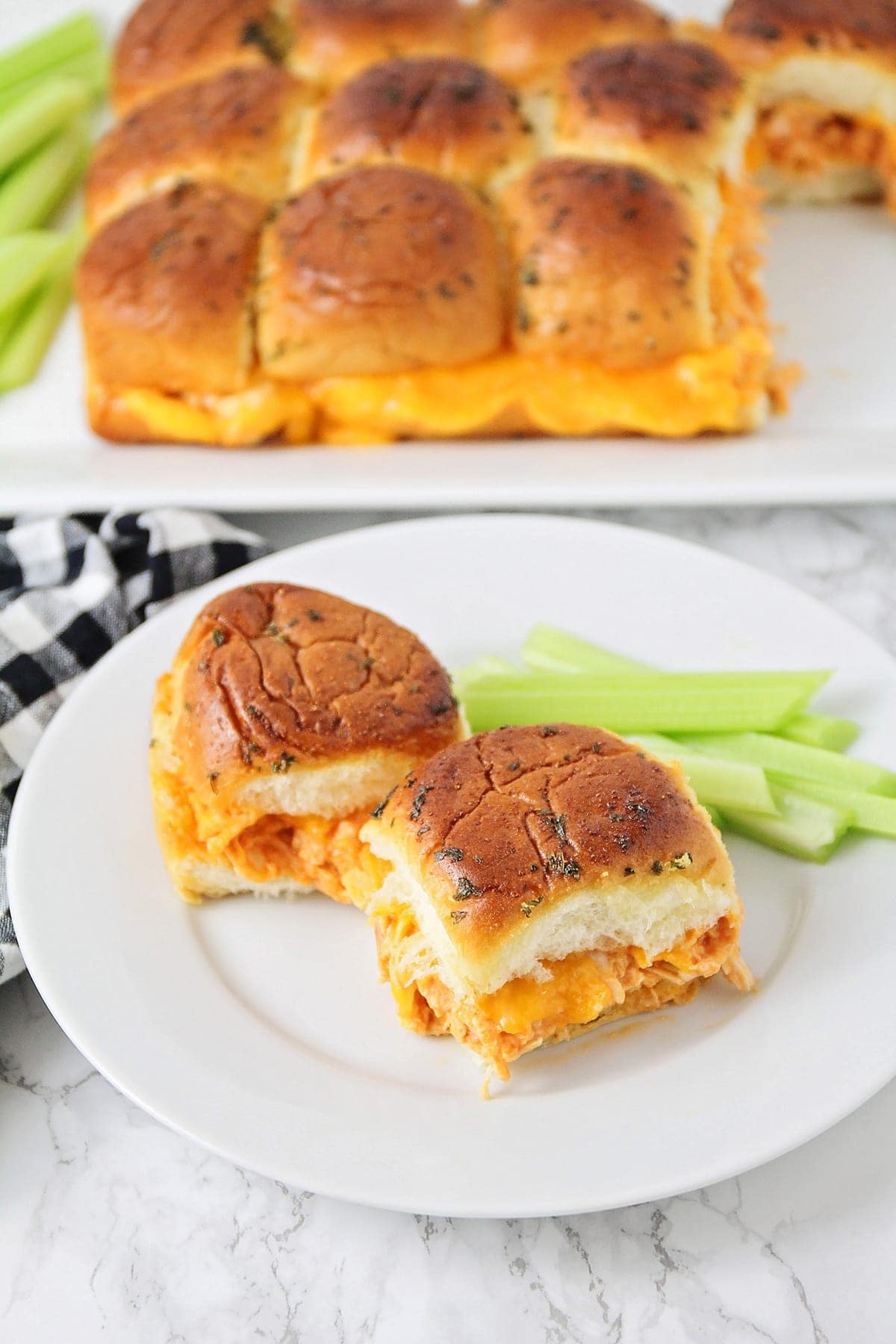 Two Buffalo Chicken Sliders on a plate served with celery.