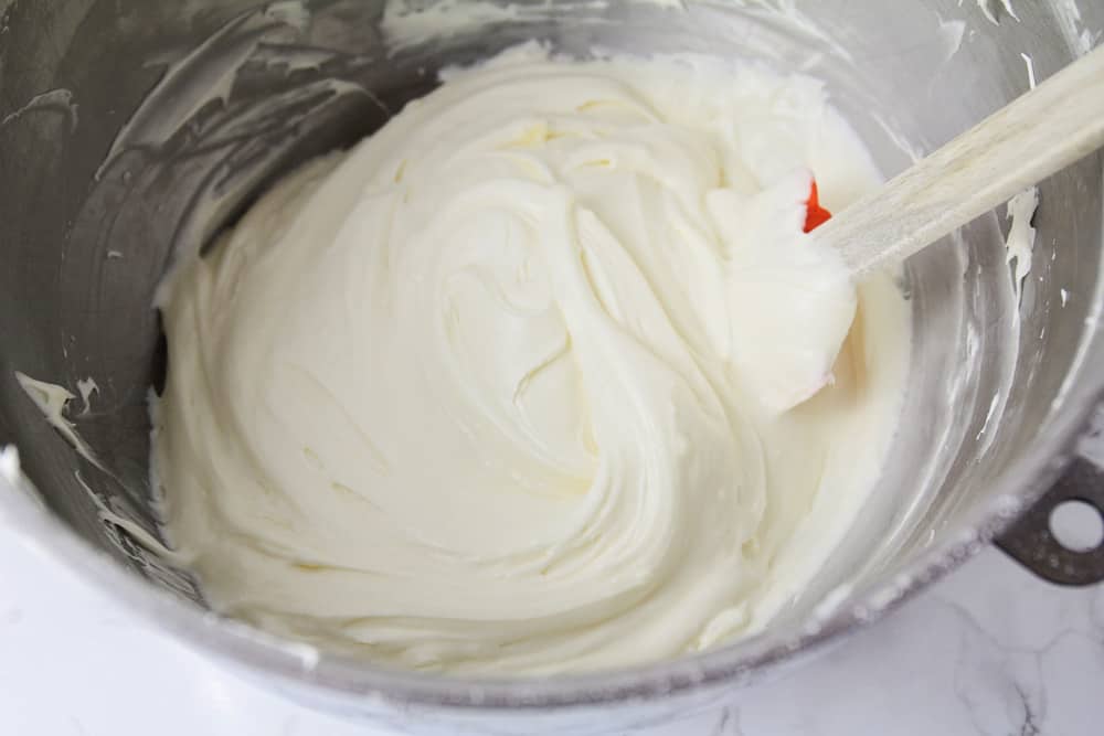 Cream cheese frosting for carrot cake whipped in a mixing bowl.