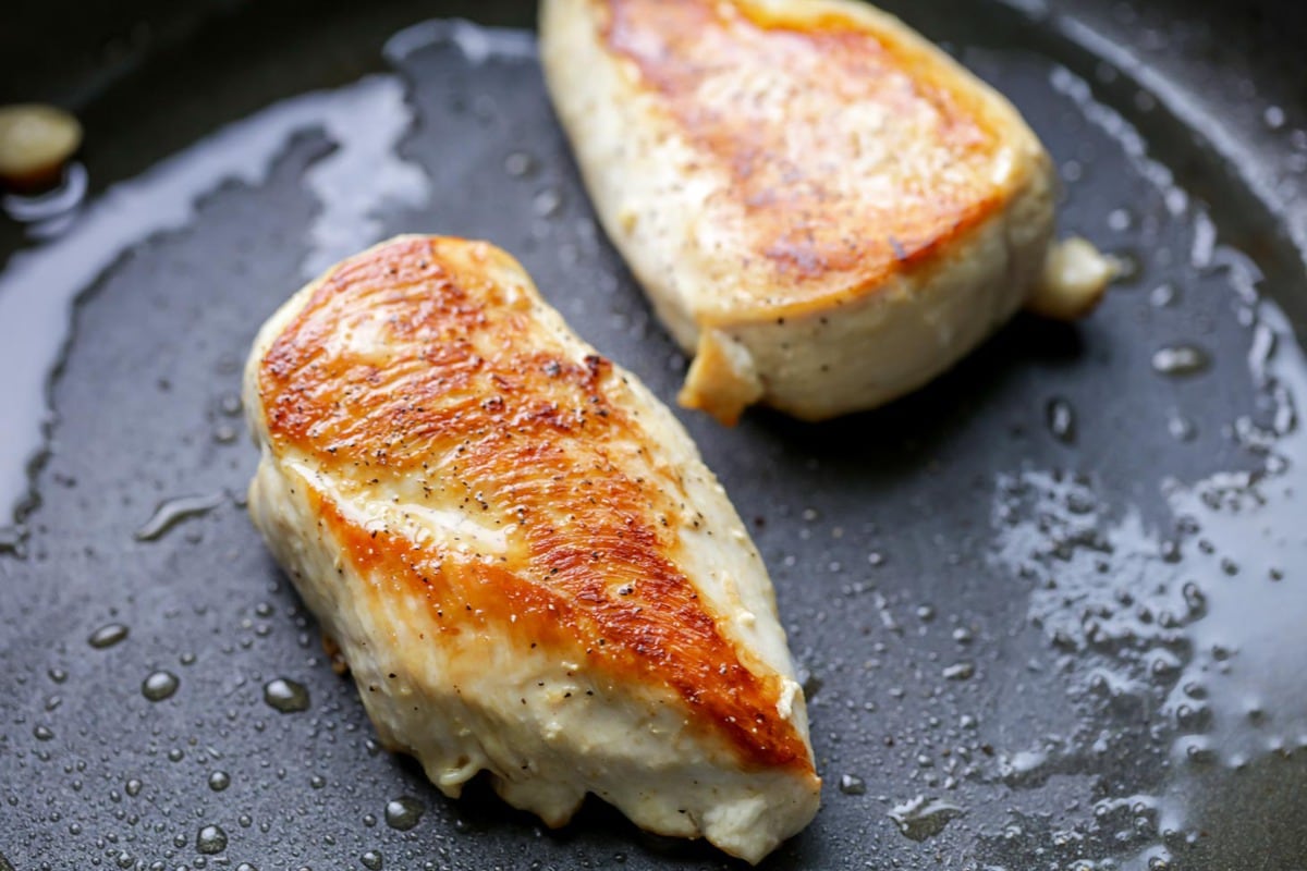 Chicken sauteed in the pan for chicken alfredo.