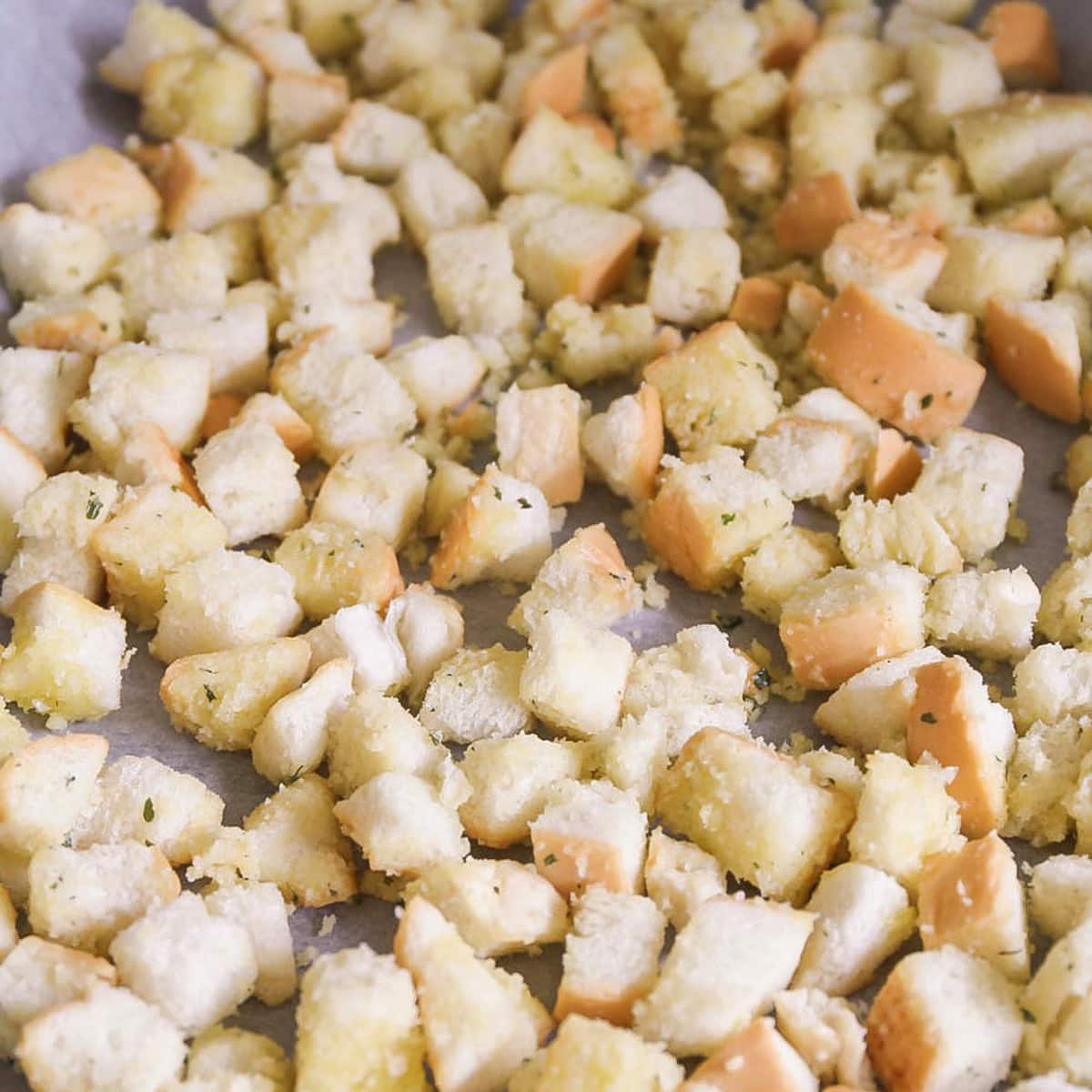 Bread cubes covered with oil and seasonings to make homemade  croutons.