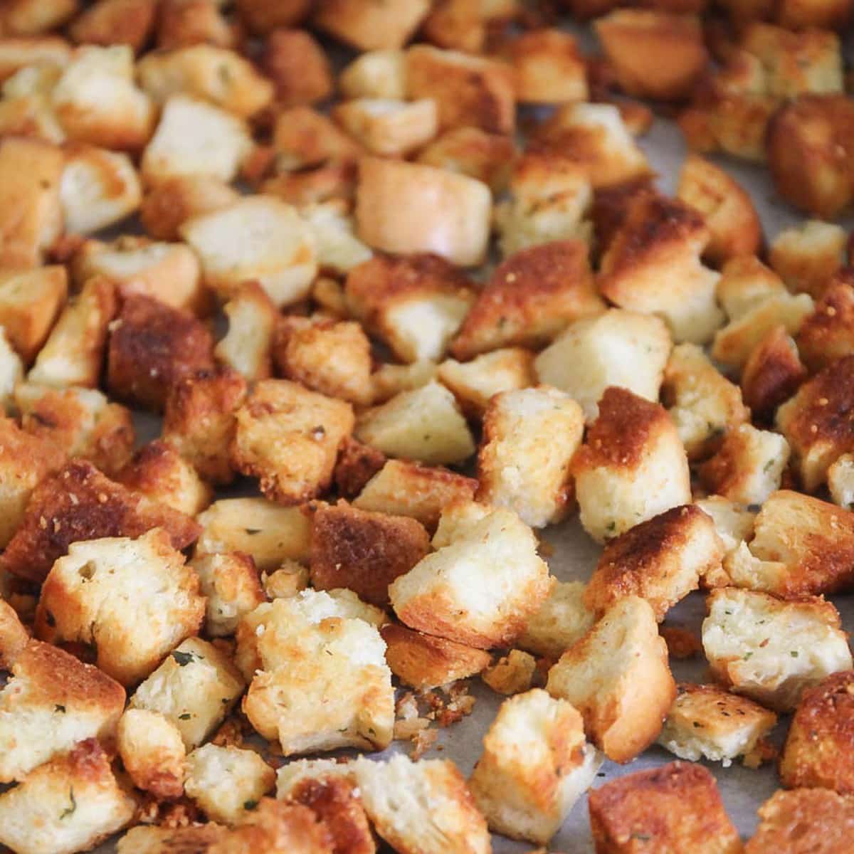 Crispy homemade croutons on a baking sheet.