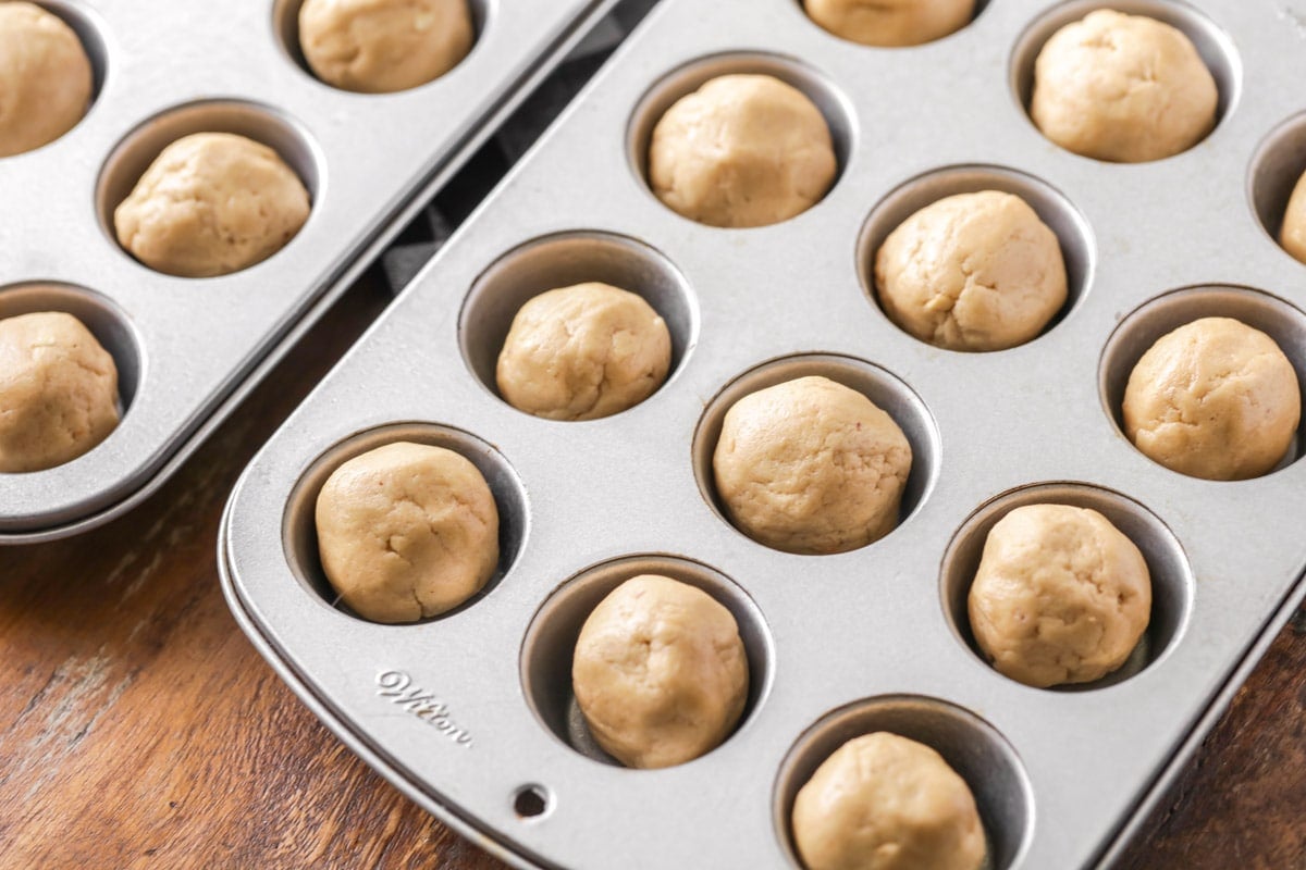 Dough balls for Peanut Butter Cup Cookie recipe in a muffin tin