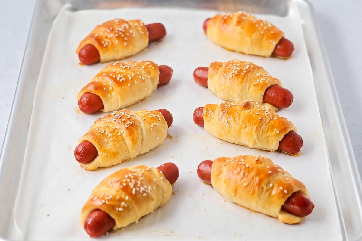 Pigs in a blanket baked on baking dish.
