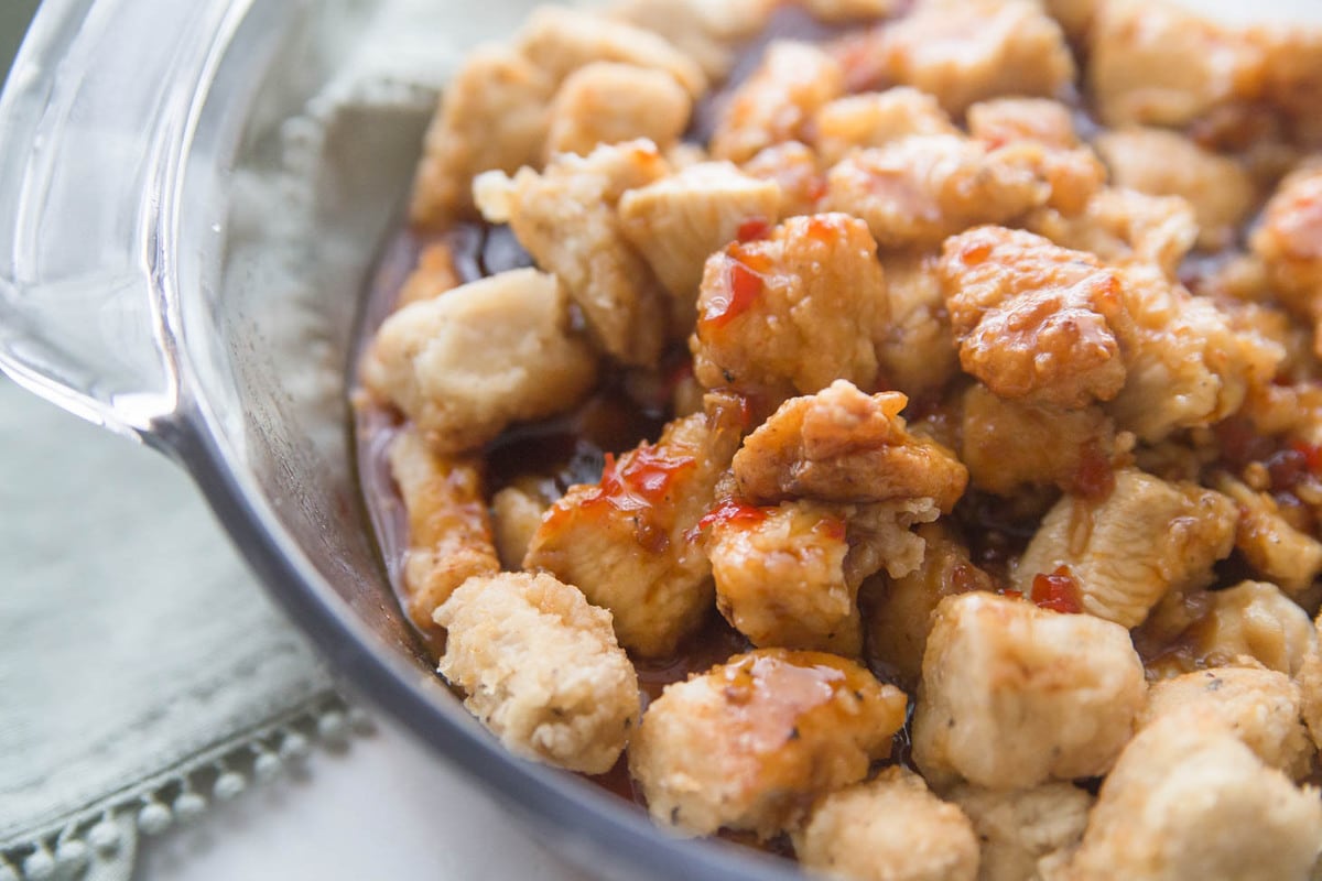 Sesame chicken in a clear glass bowl. 