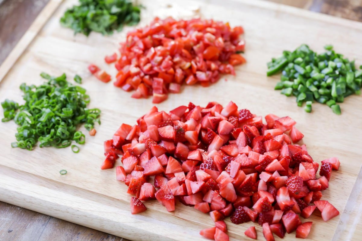 Chopped Strawberry Salsa ingredients on a cutting board.