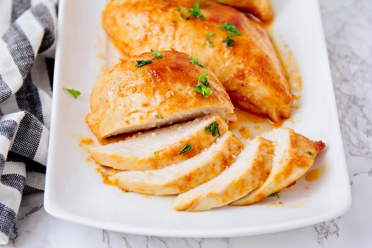 Baked bbq chicken sliced and served on a white platter.