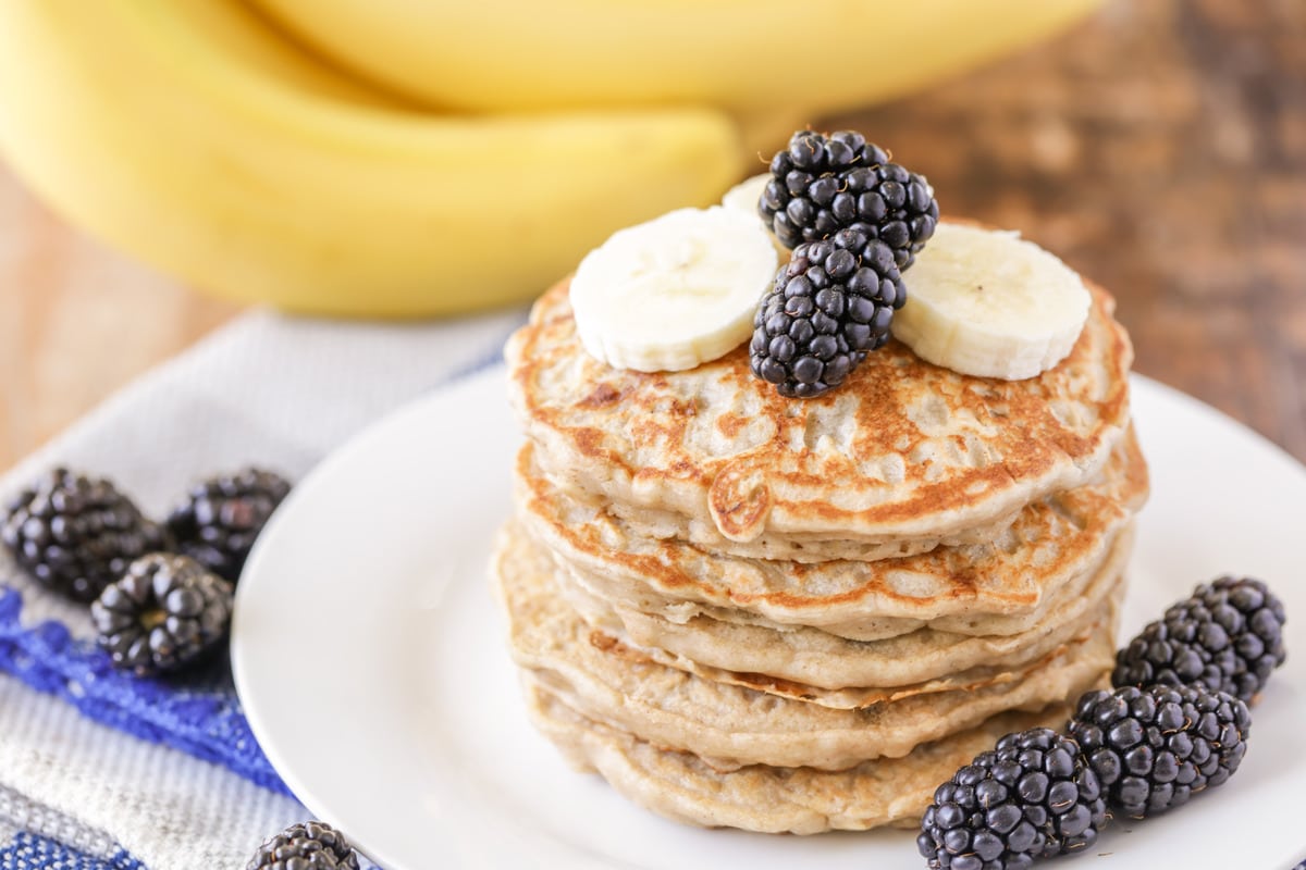 Stack of banana oatmeal pancakes on a white plate