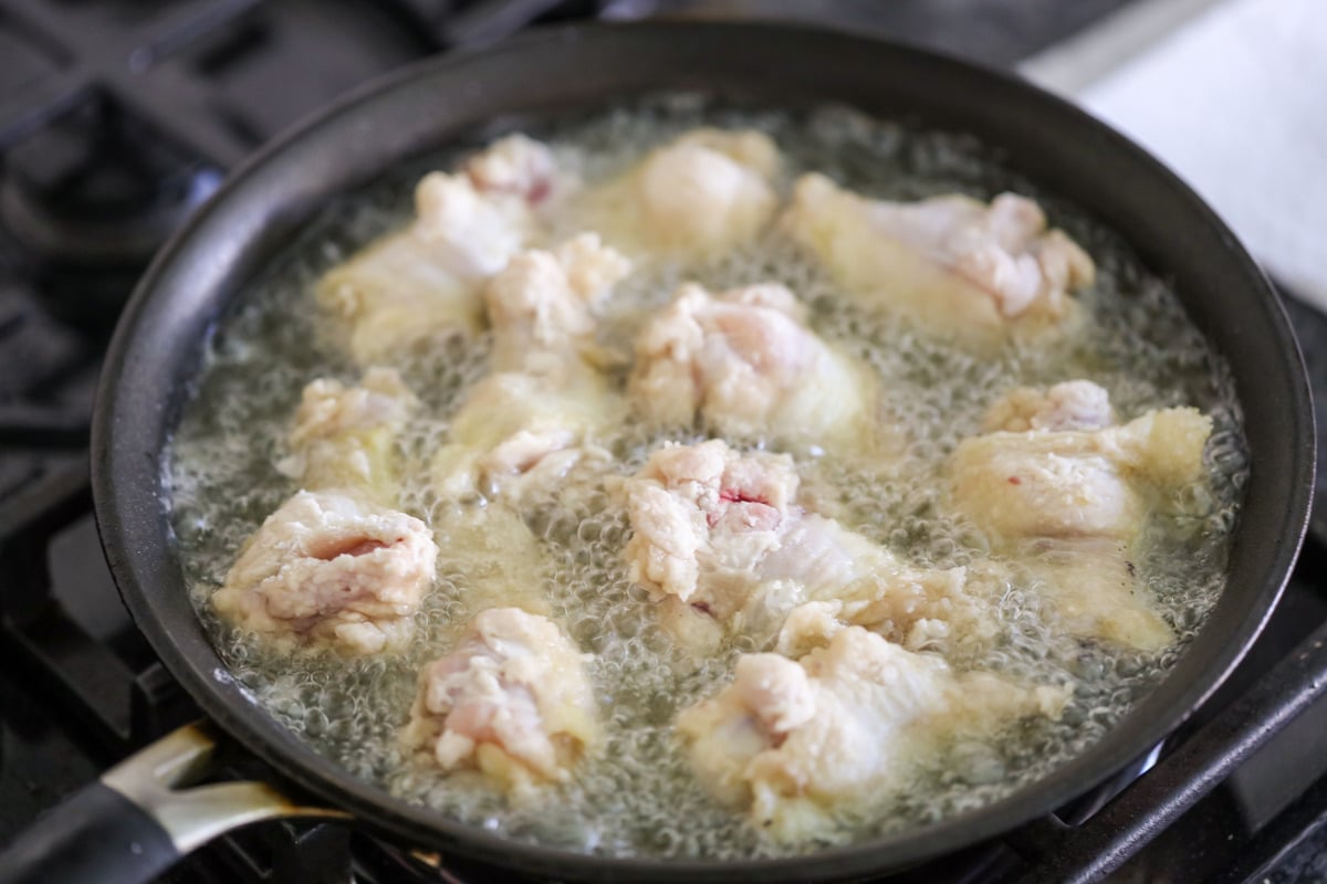 Frying hot wings in a pan.