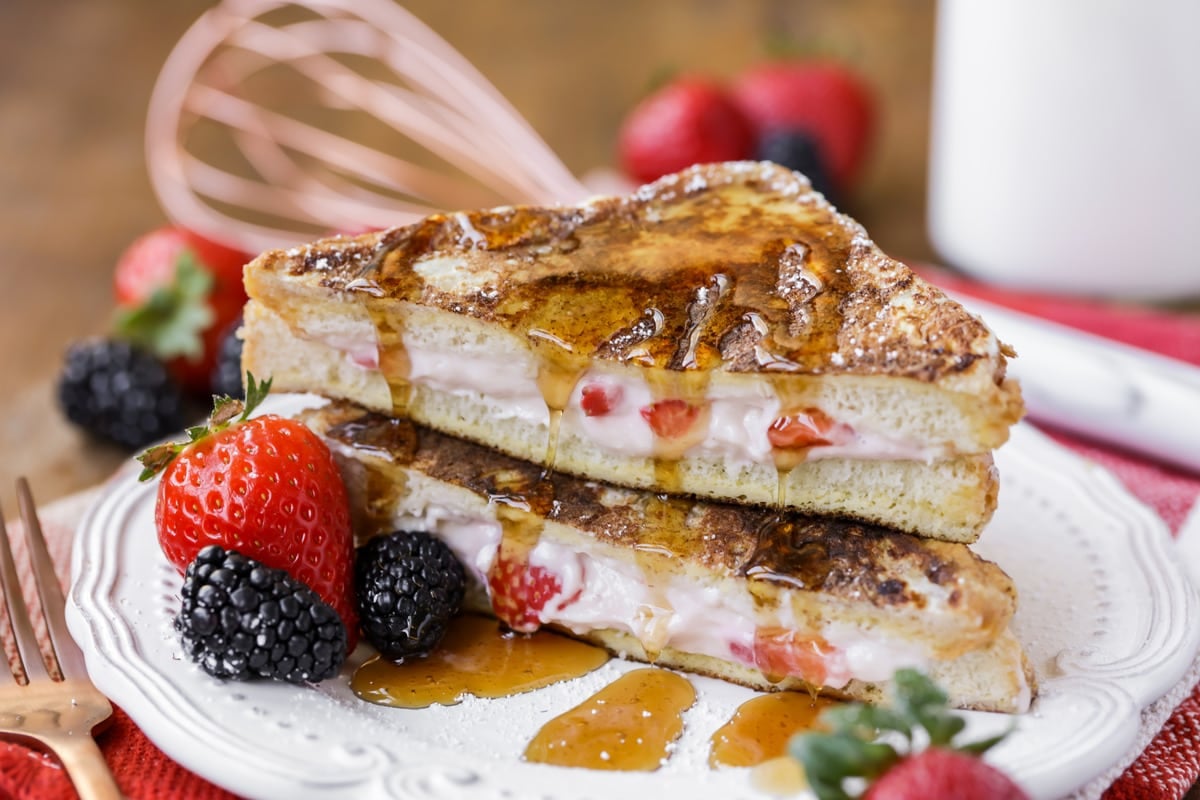 stuffed french toast topped with syrup and served with fresh berries