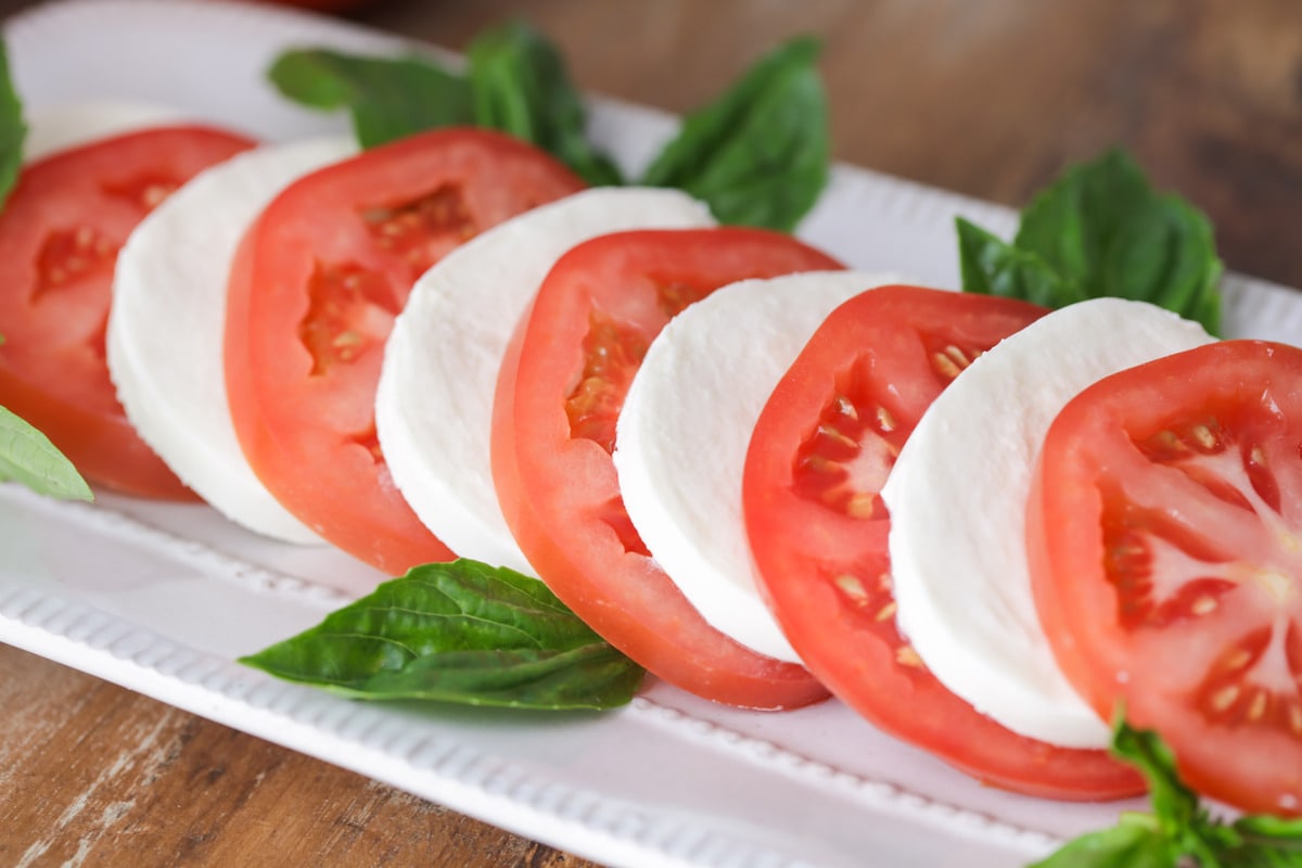 Slices of tomato and mozzarella with fresh basil.