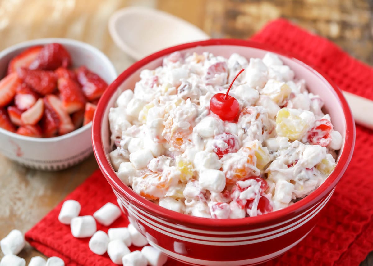 Christmas side dishes - ambrosia salad topped with a maraschino cherry.