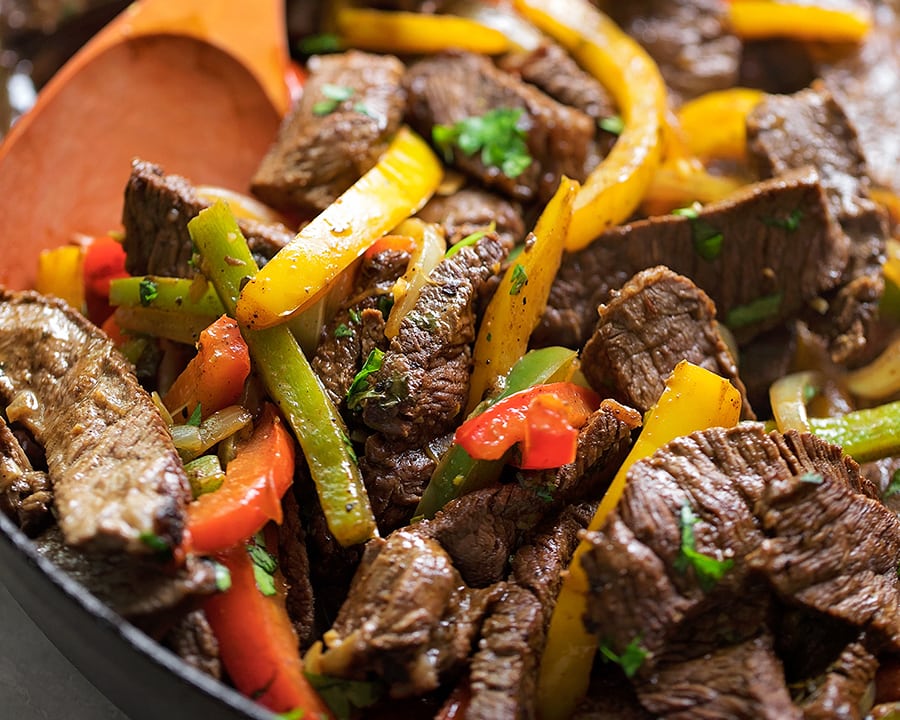 Cooking steak and vegetables in a frying pan