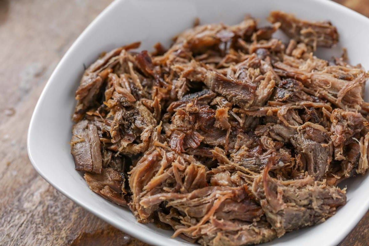 Shredded beef in a white bowl.