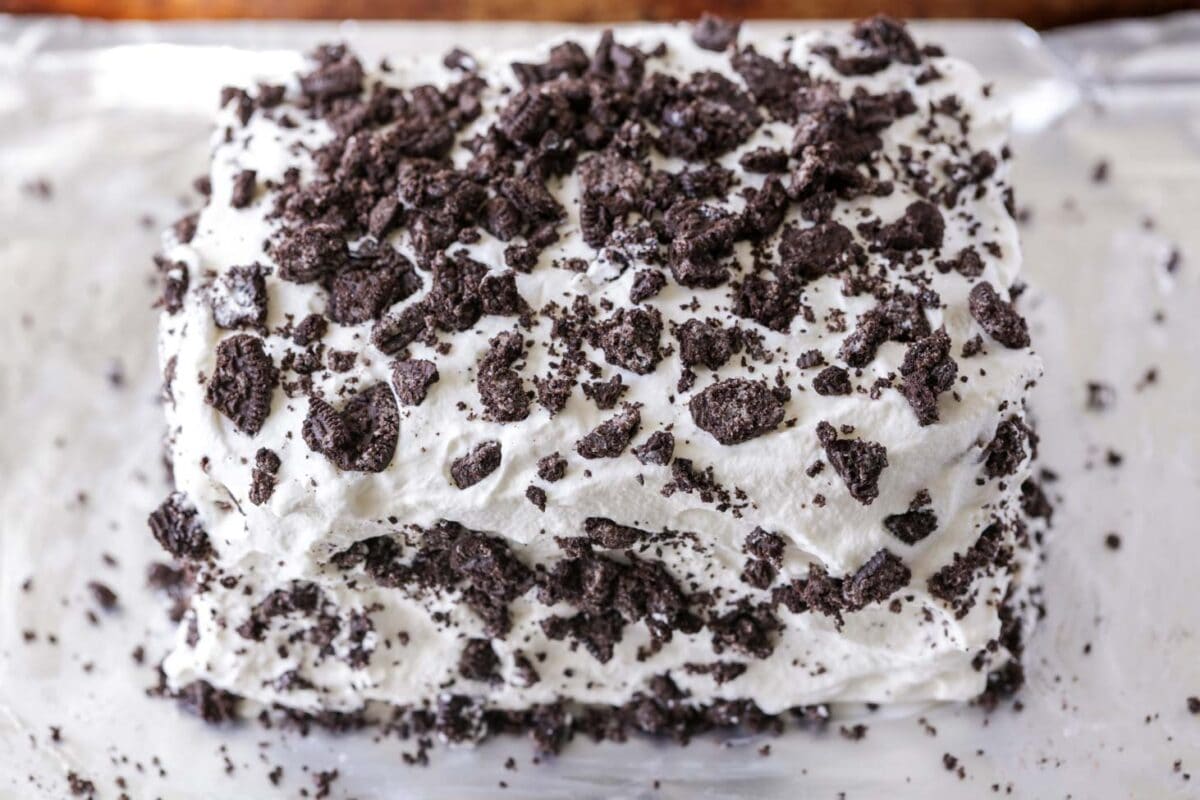 Ice cream sandwiches covered in whipped cream and Chopped Oreos.