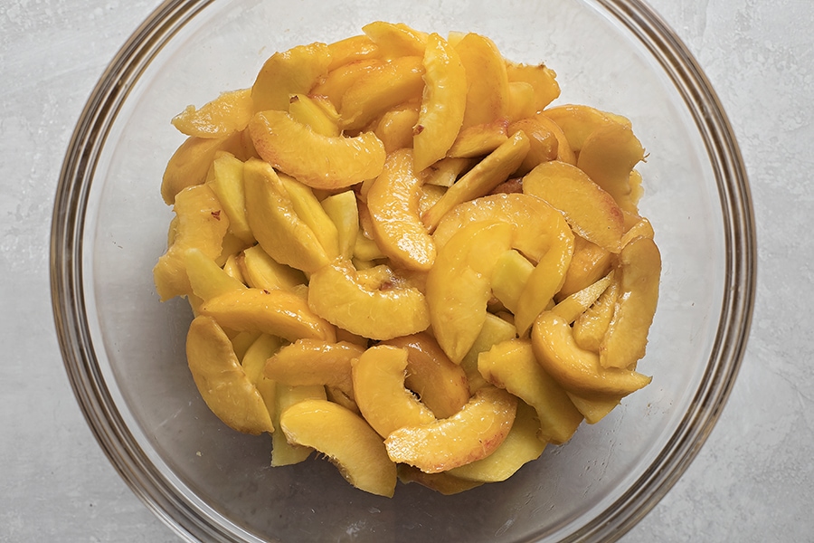 Fresh peach slices in a bowl for peach pie filling.