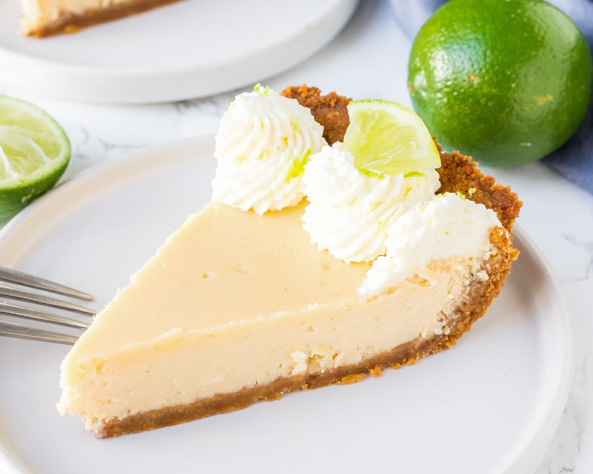 A slice of key lime pie on a white plate.