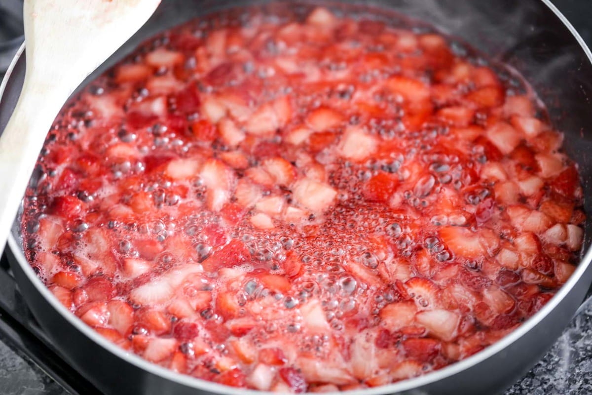 Homemade strawberry sauce cooking in a skillet