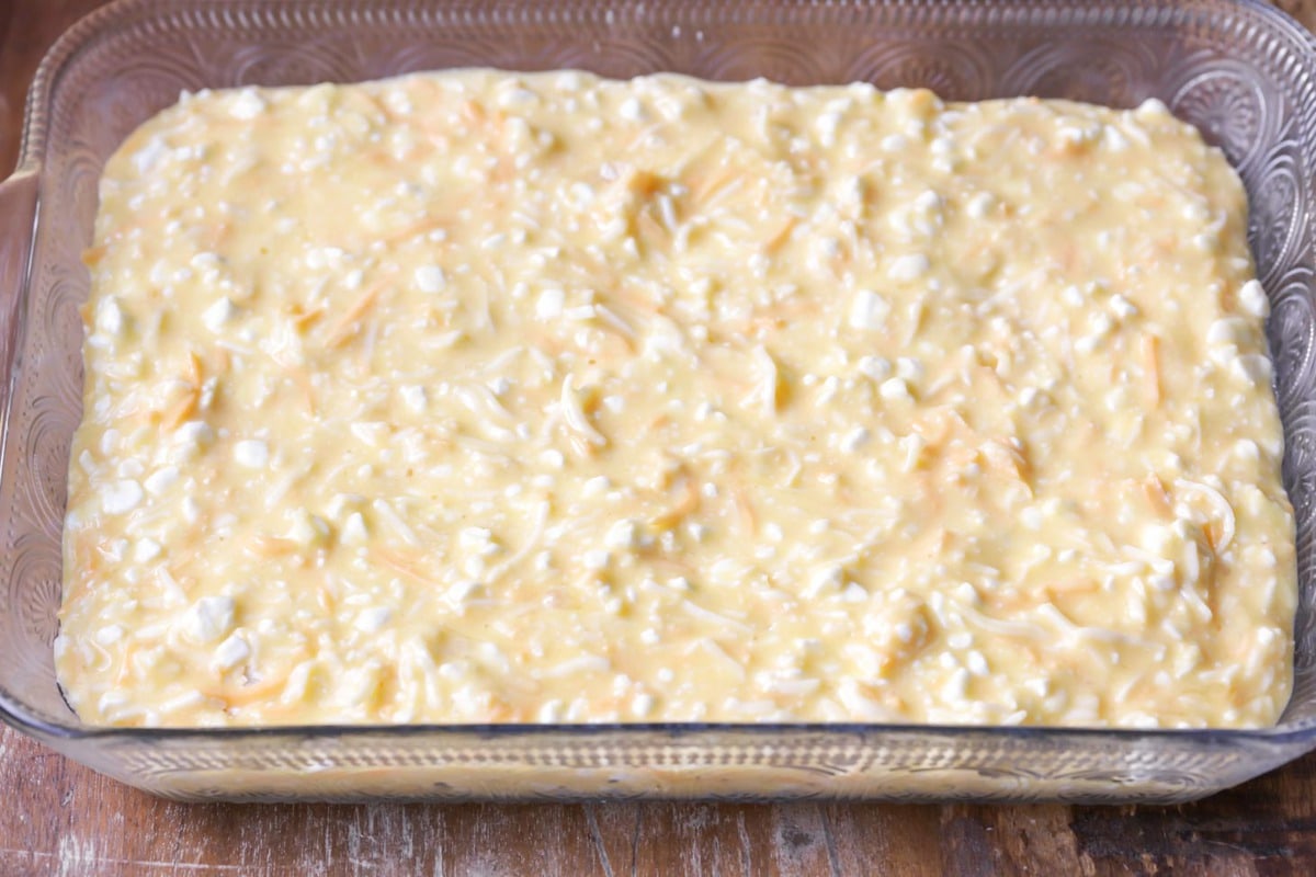 Baked eggs mixture in a glass baking dish ready to be baked.