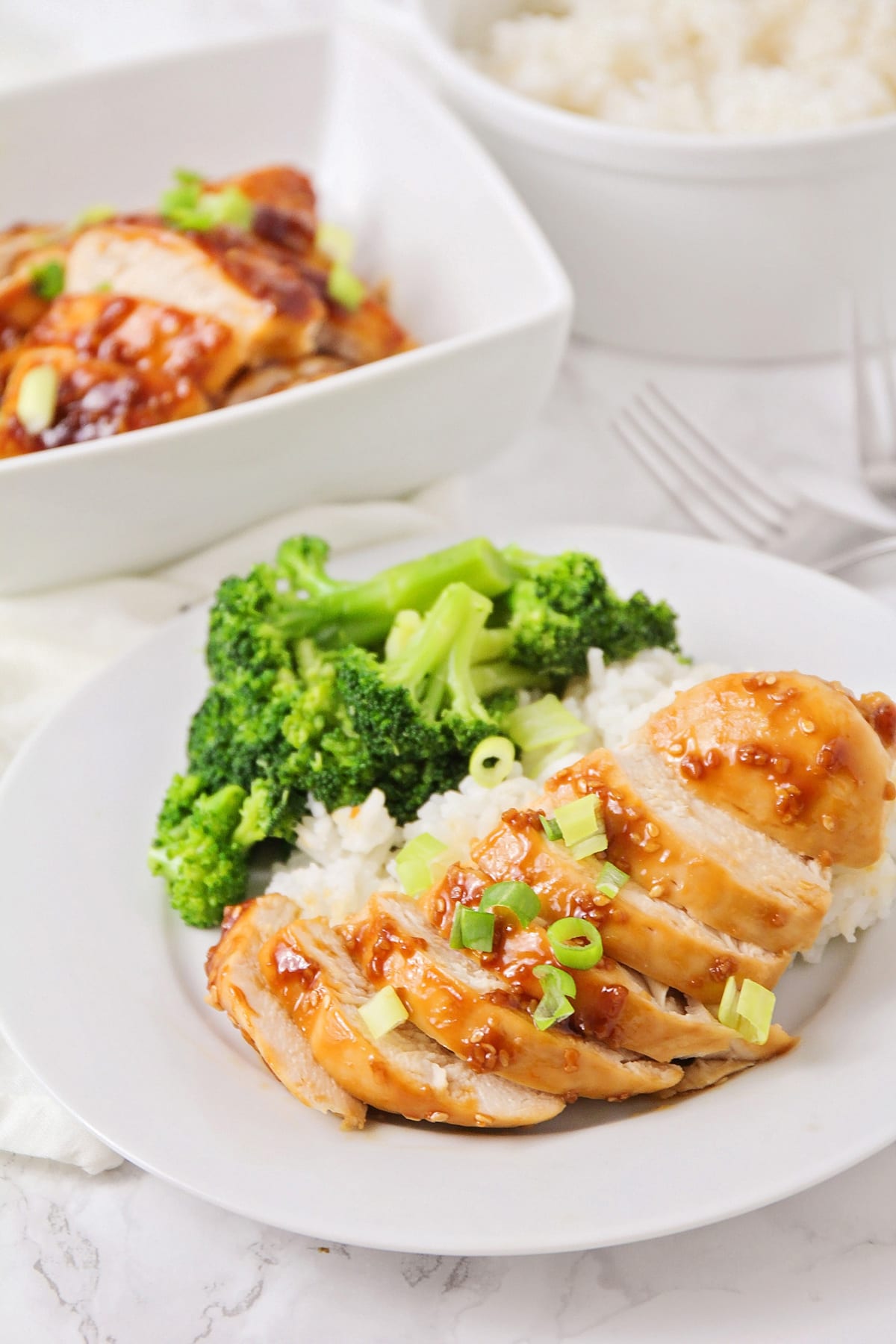 Baked teriyaki chicken served on top of white rice with steamed broccoli.