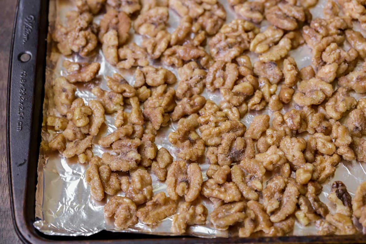Walnuts spread on a lined cookie sheet.