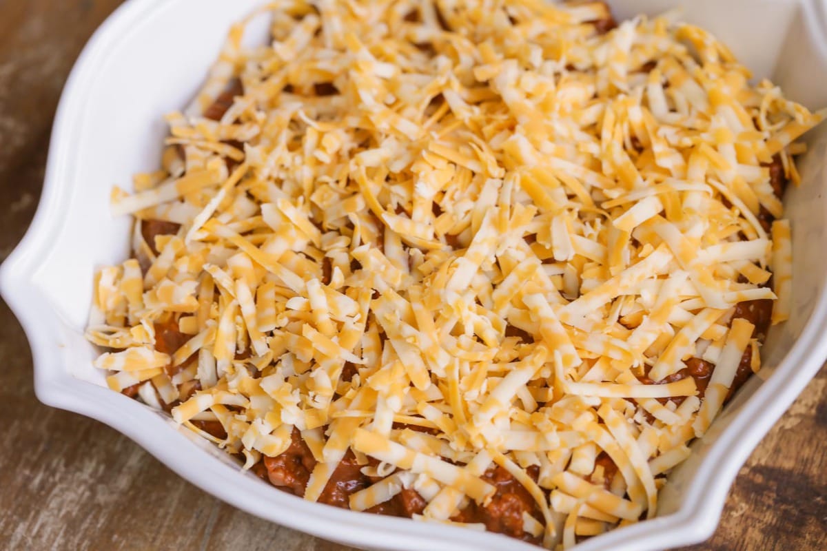 Shredded cheese on top of hormel chili cheese dip.