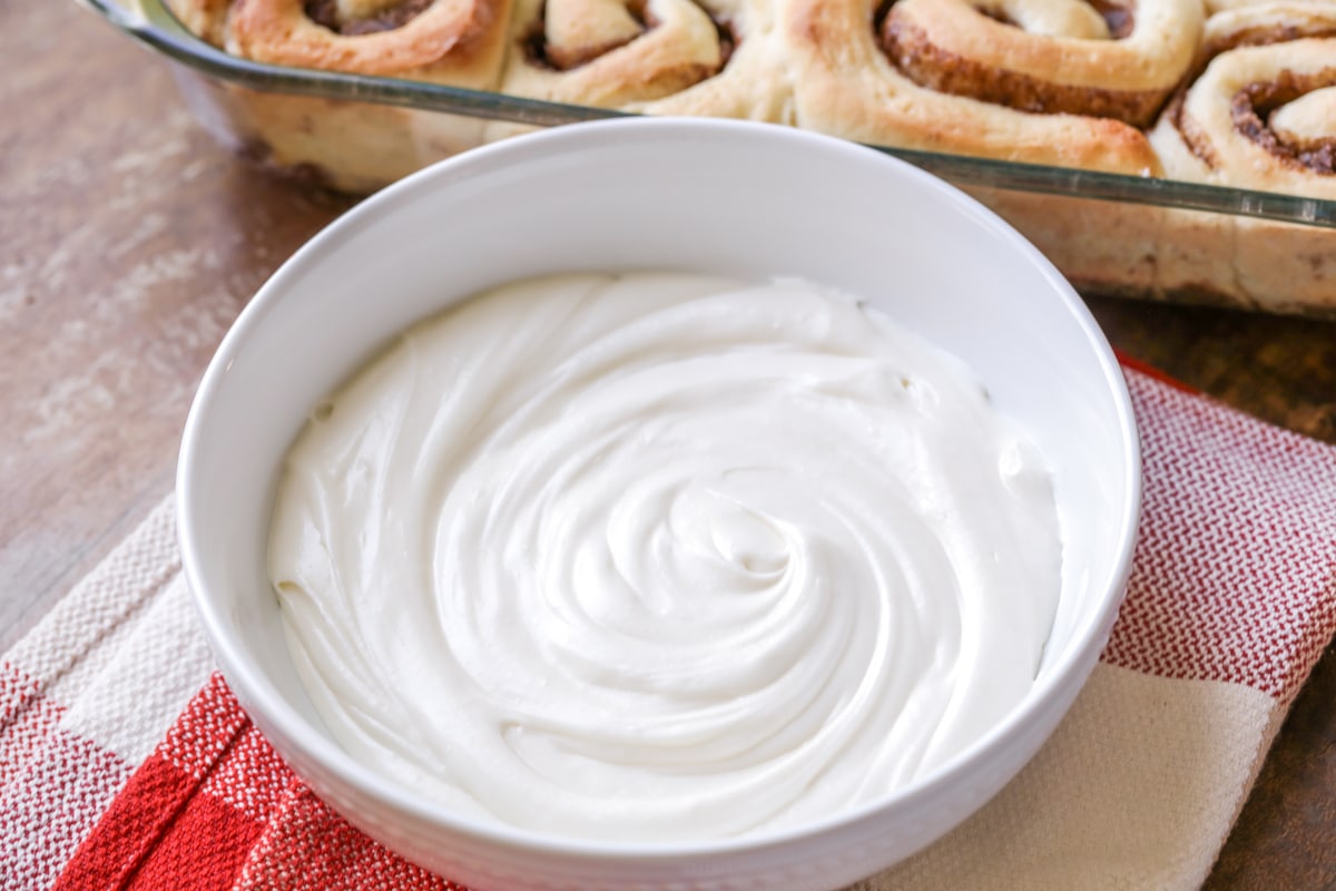 Cream cheese frosting whipped up in a white bowl.