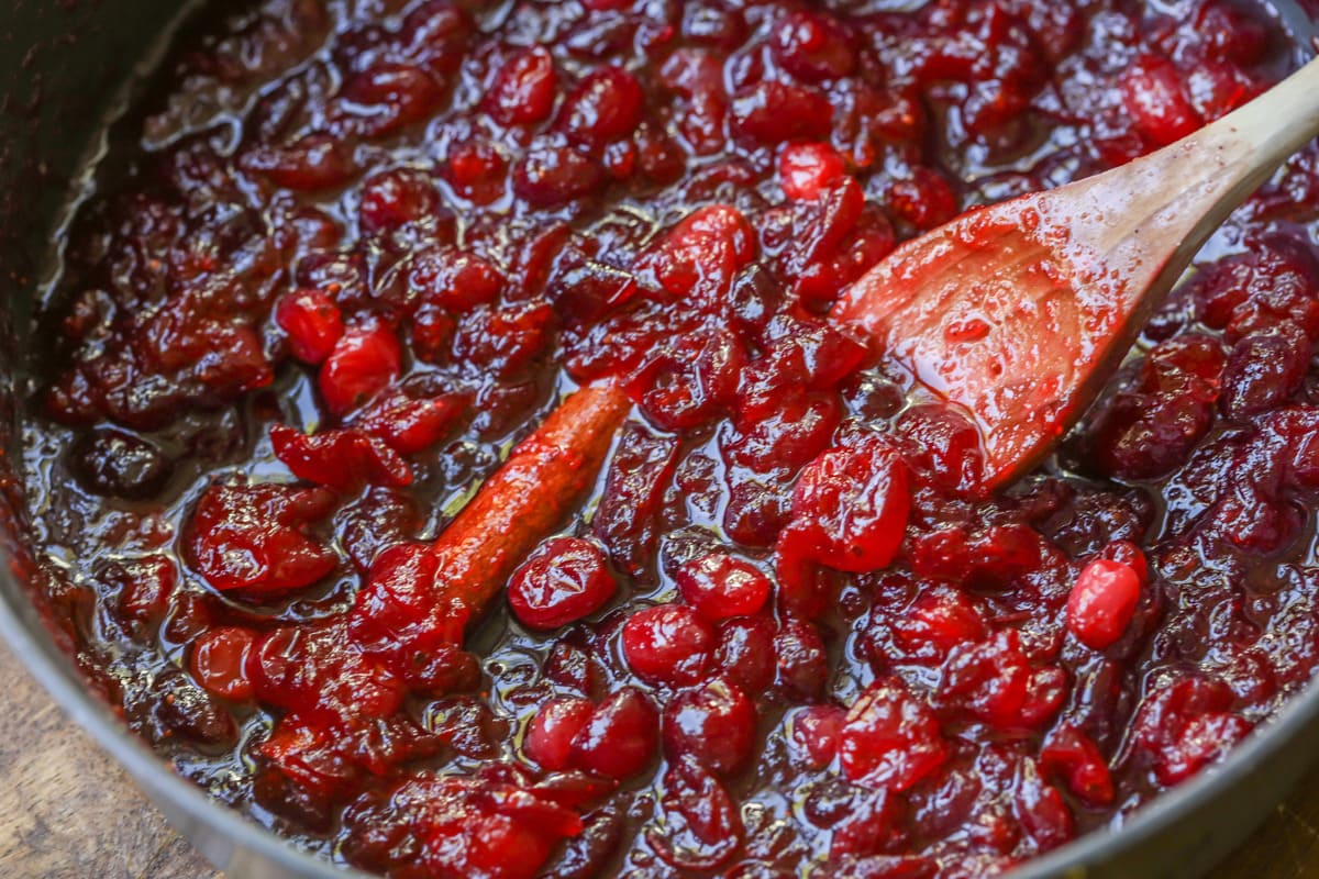 Fresh cranberry sauce breaking down in a pan.