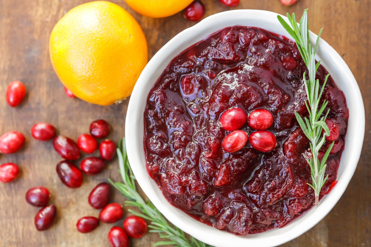 Fresh Cranberry Sauce in a small white bowl topped with fresh rosemary.