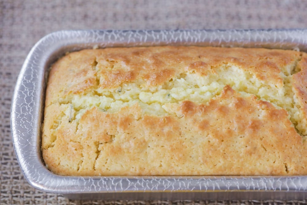 A baked loaf of zucchini lemon bread recipe in a loaf pan.