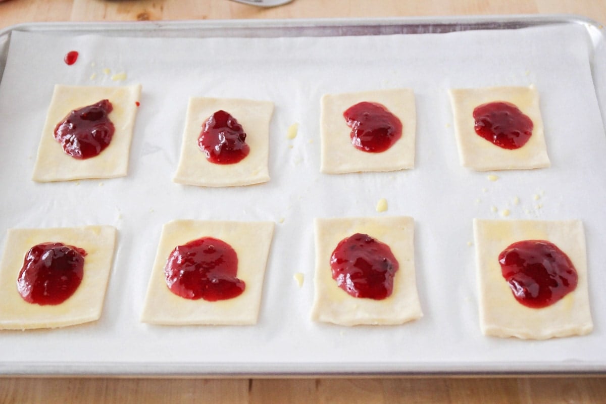 Adding strawberry filling to the pop tart crust