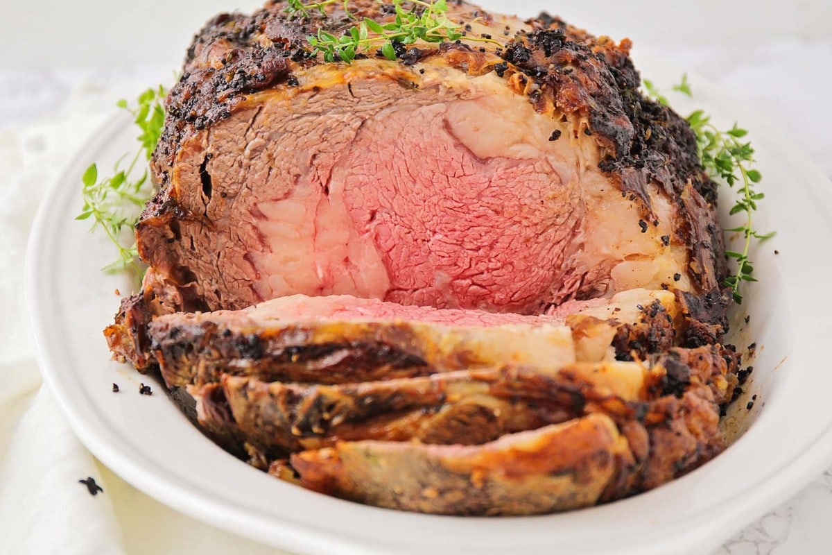 Thanksgiving dinner ideas - garlic prime rib sliced and topped with herbs.