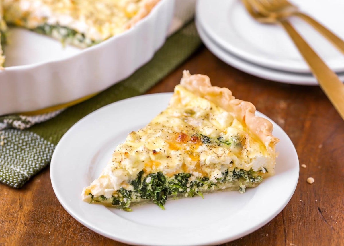 Breakfast Egg Recipes - a slice of spinach quiche on a white plate. 