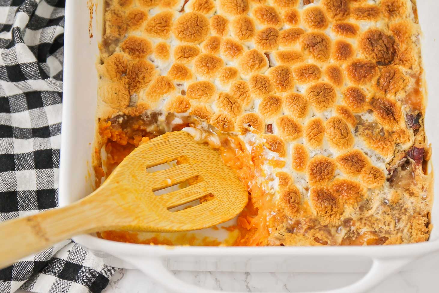 Thanksgiving dinner ideas - sweet potato casserole with marshmallows, with a scoop missing.