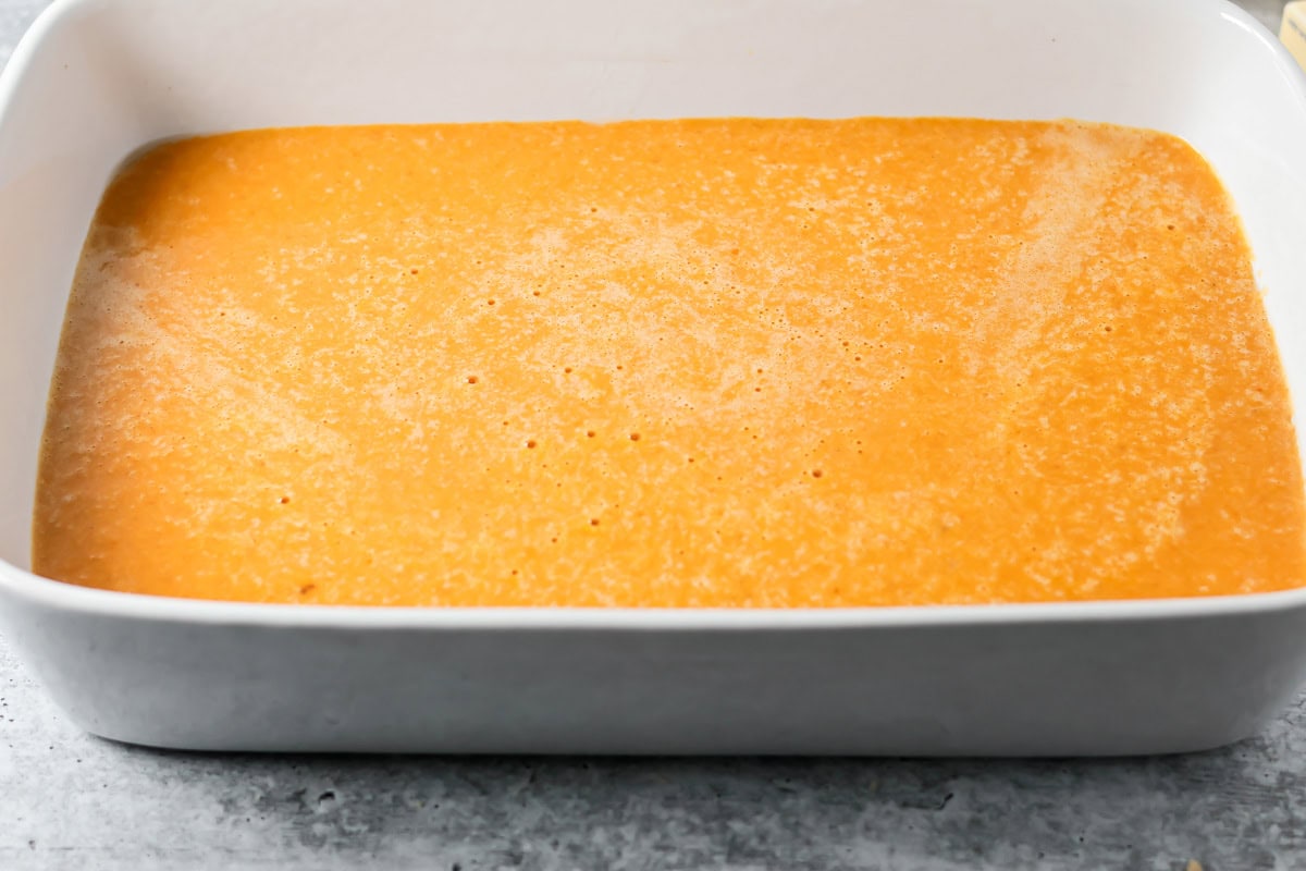 Pumpkin crunch cake batter poured into baking dish.
