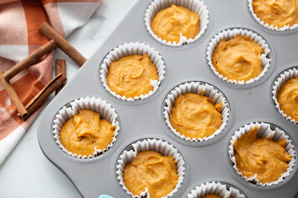 Pumpkin cupcake batter in muffin liners