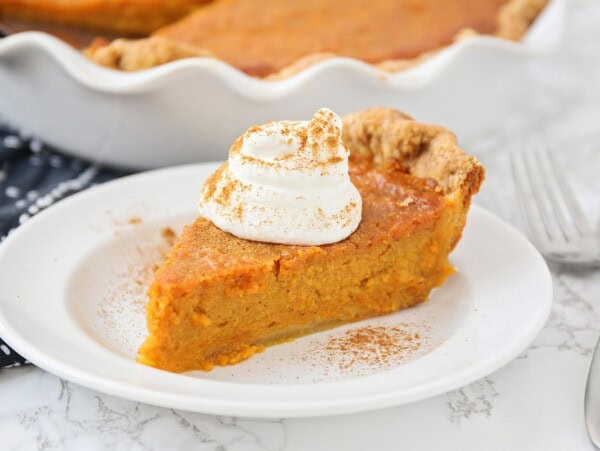 A slice of sweet potato pie on a white plate.