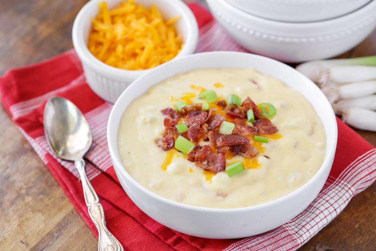 Easy soup recipes - bacon topped cheesy potato soup in a white bowl.