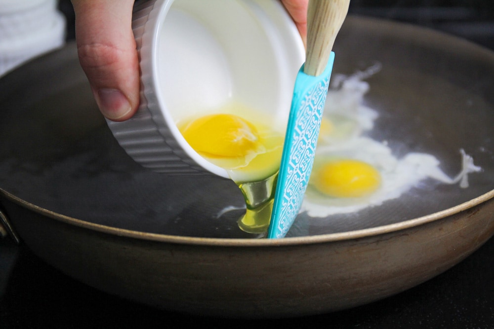 Cooking eggs in a pan for eggs Benedict recipe
