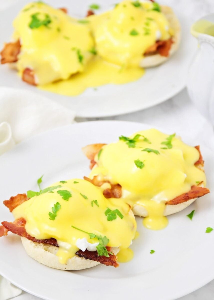 Close up of how to make eggs Benedict smothered in homemade hollandaise sauce.