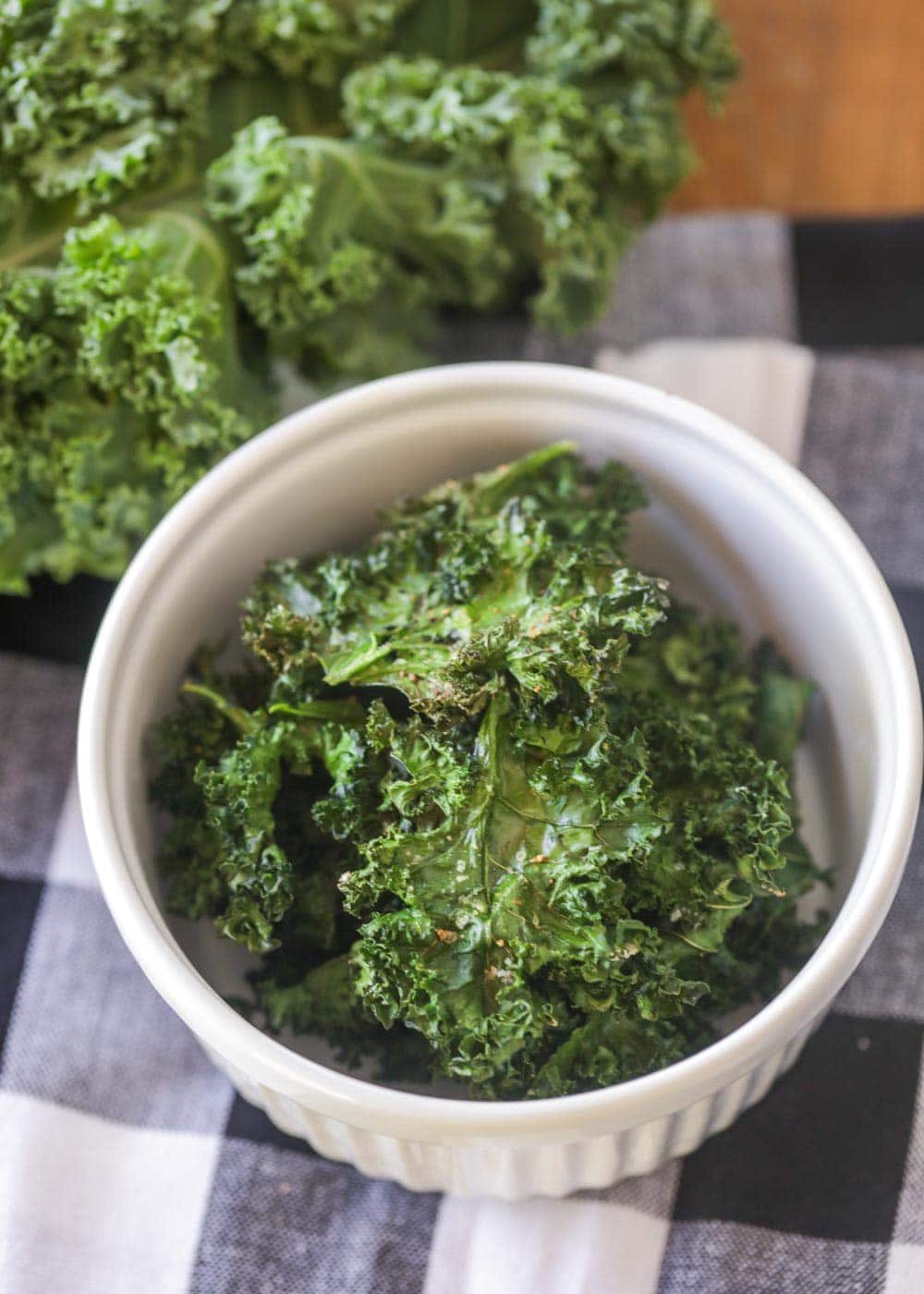 Close up of baked kale chips in a white dish