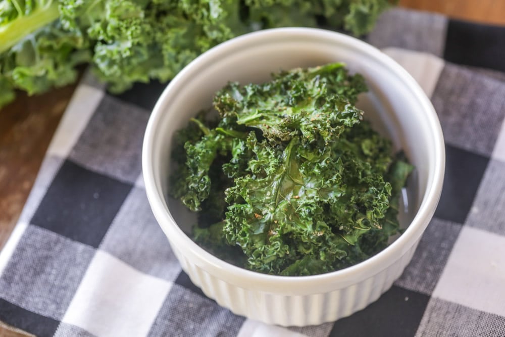 Baked kale chips in a white ramekin.