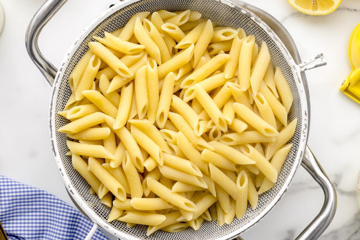 A colander filled with cooked and cooled pasta.