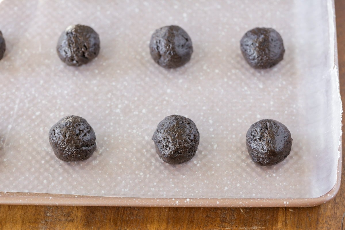 Oreo balls on a lined baking sheet.
