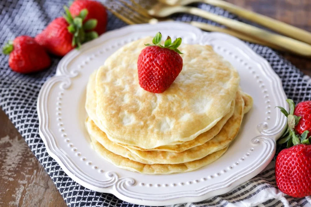 Uma pilha de panquecas proteicas com um morango por cima