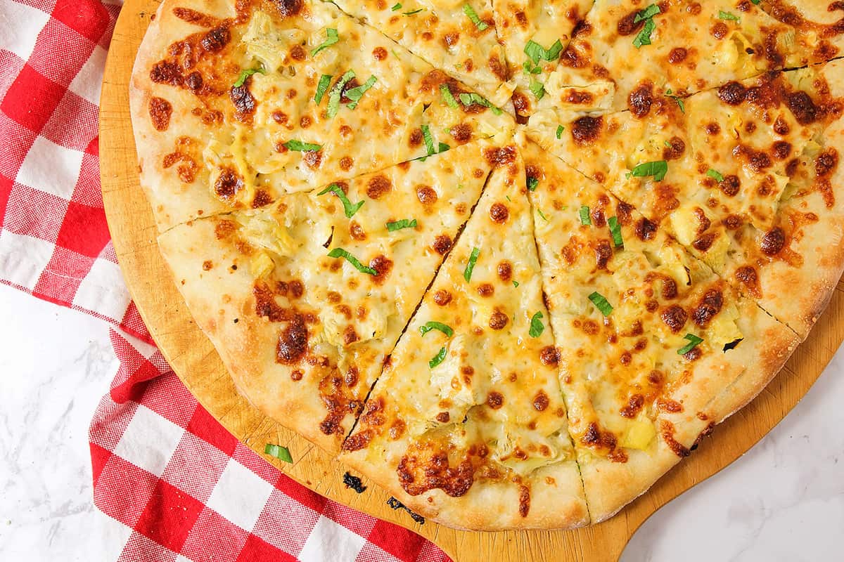 Artichoke Pizza cut into slices.