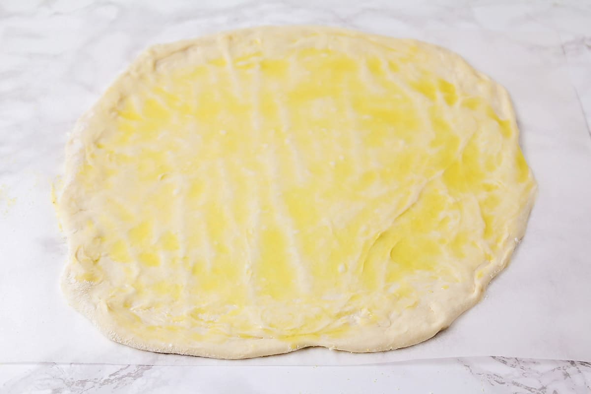 Pizza dough spread with olive oil.