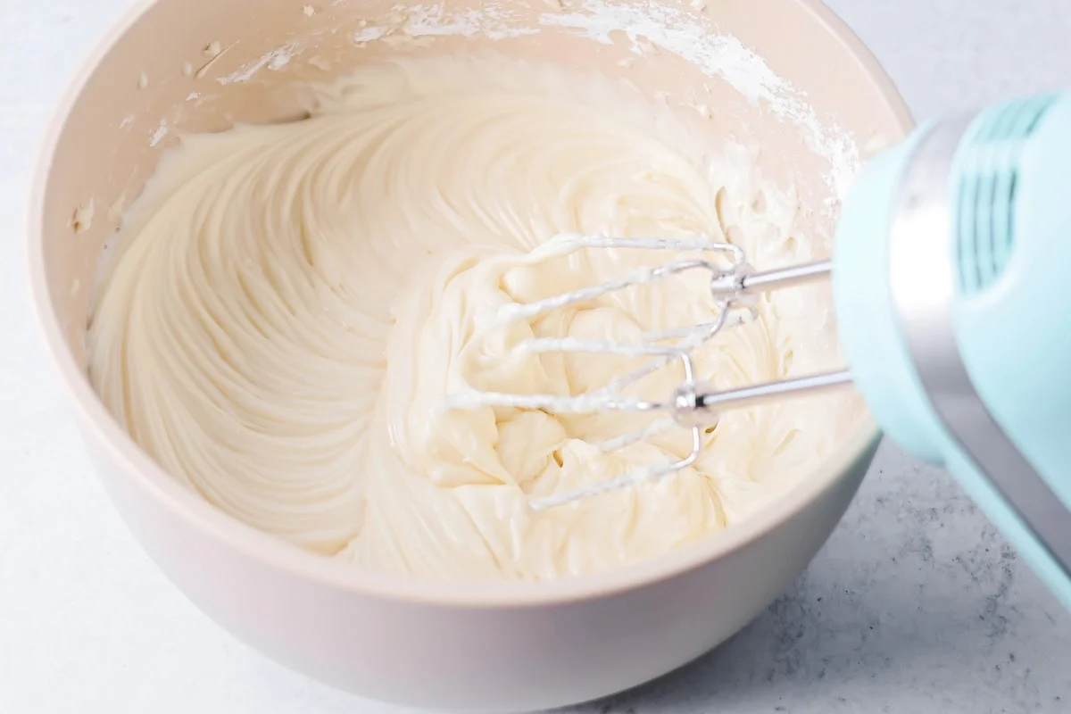 Cinnamon roll icing creamed together in mixing bowl. 
