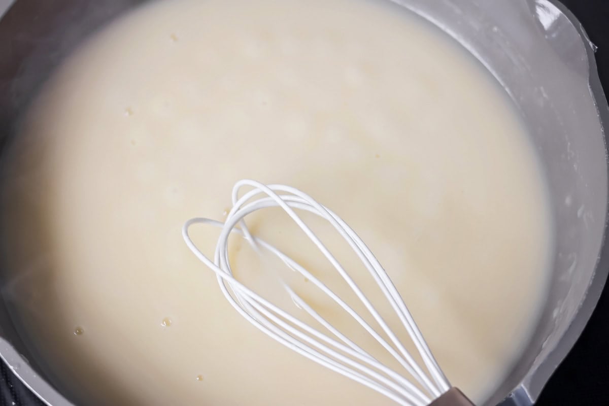 Whisking turkey gravy without drippings in a pot.
