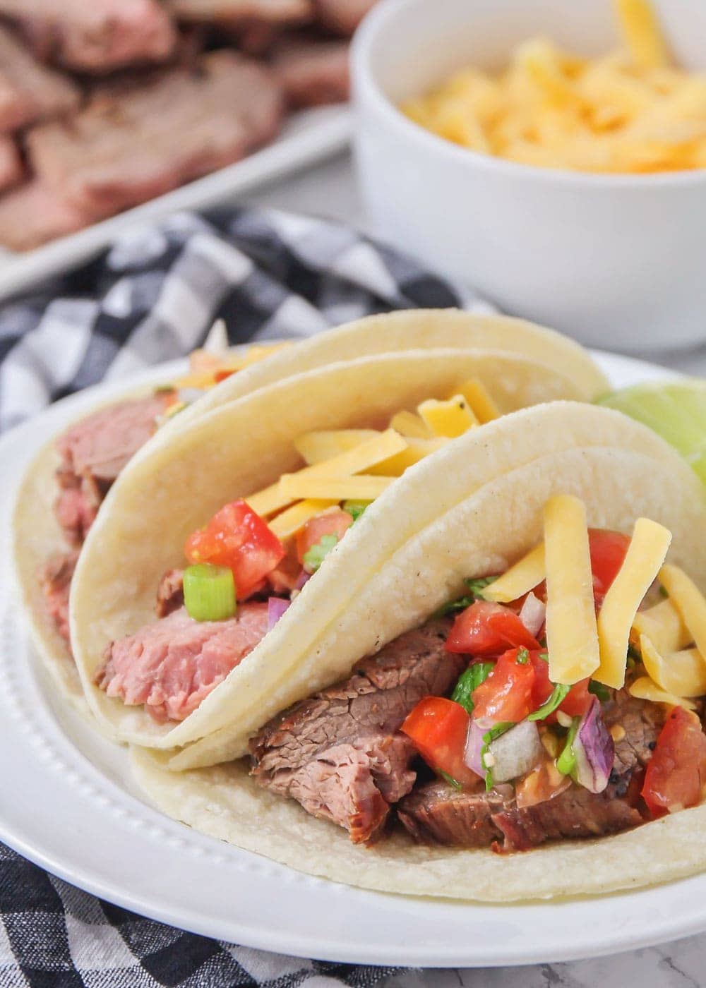 Close up of carne asada street tacos on a white plate.