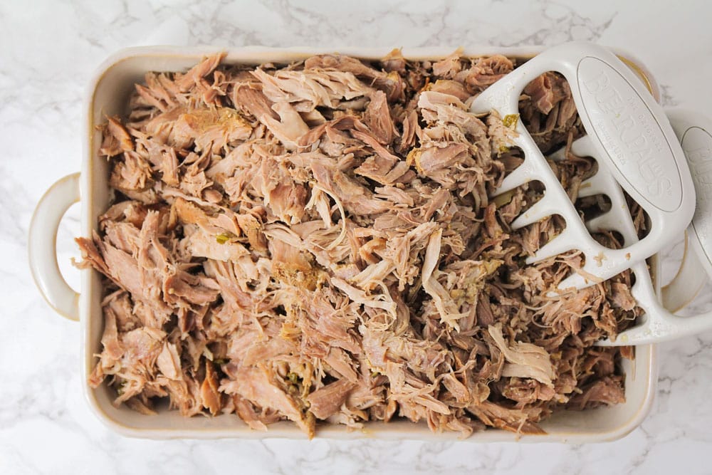 Homemade carnitas aka Mexican slow cooker pulled pork shredded in a baking dish.